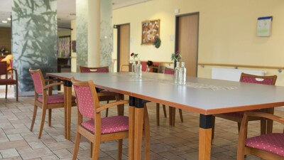 Blick in den Gemeinschaftsraum mit Tischen und Stühlen